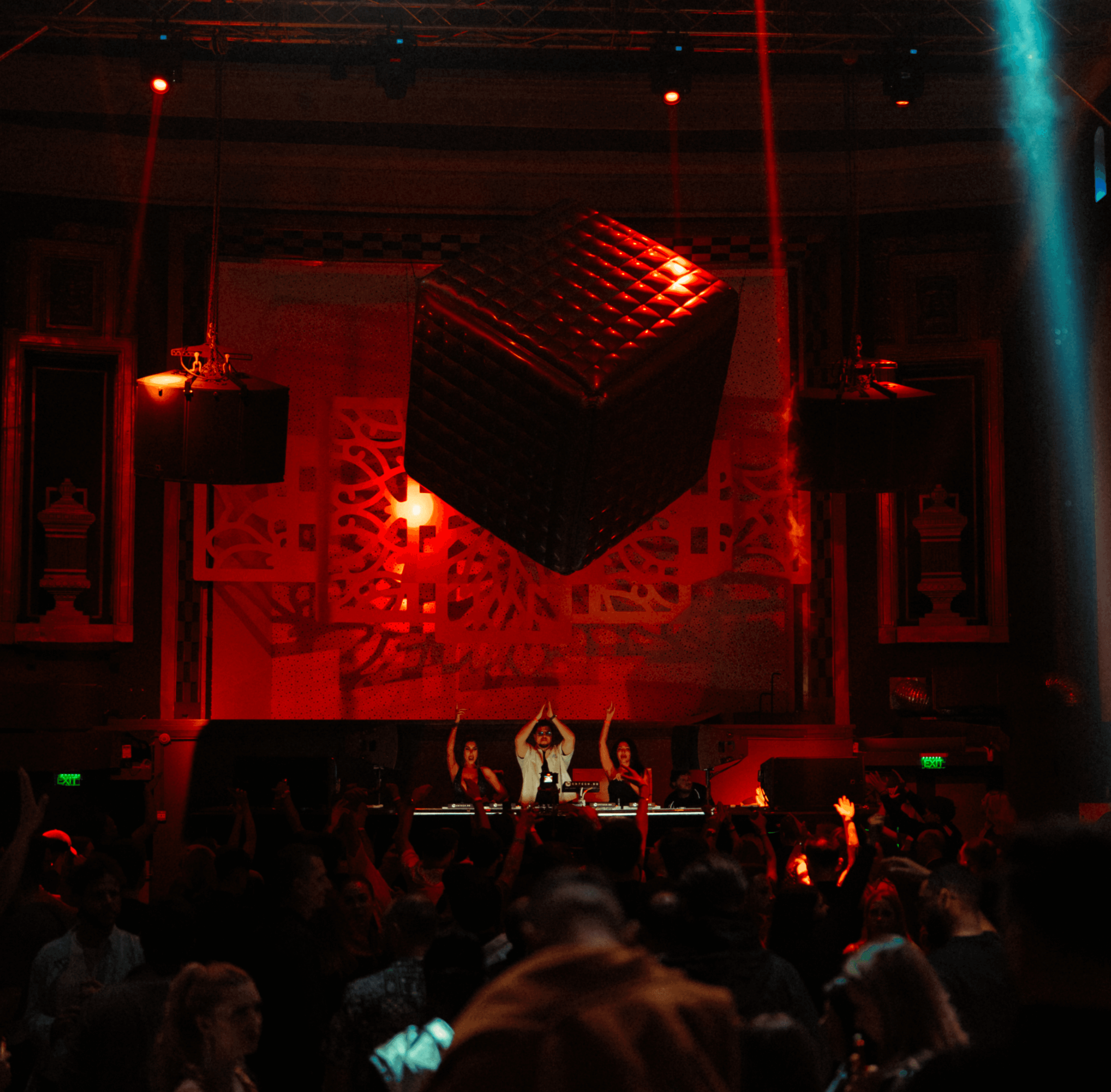 Crowd and DJs under red lights at a House of Feel night